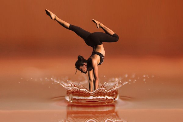 Woman doing handstand yoga pose on the water