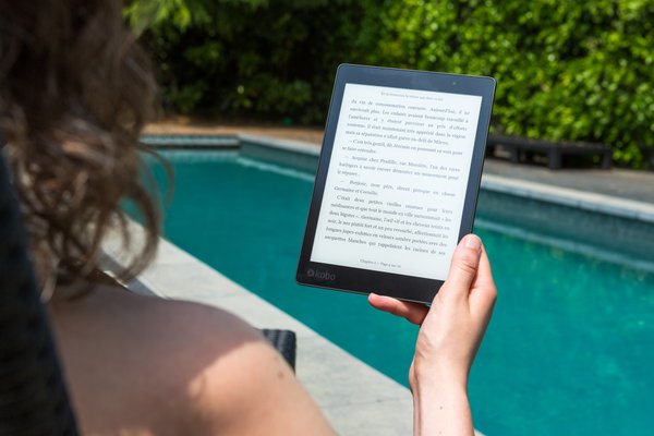 Frau am Pool liest ein E-Book